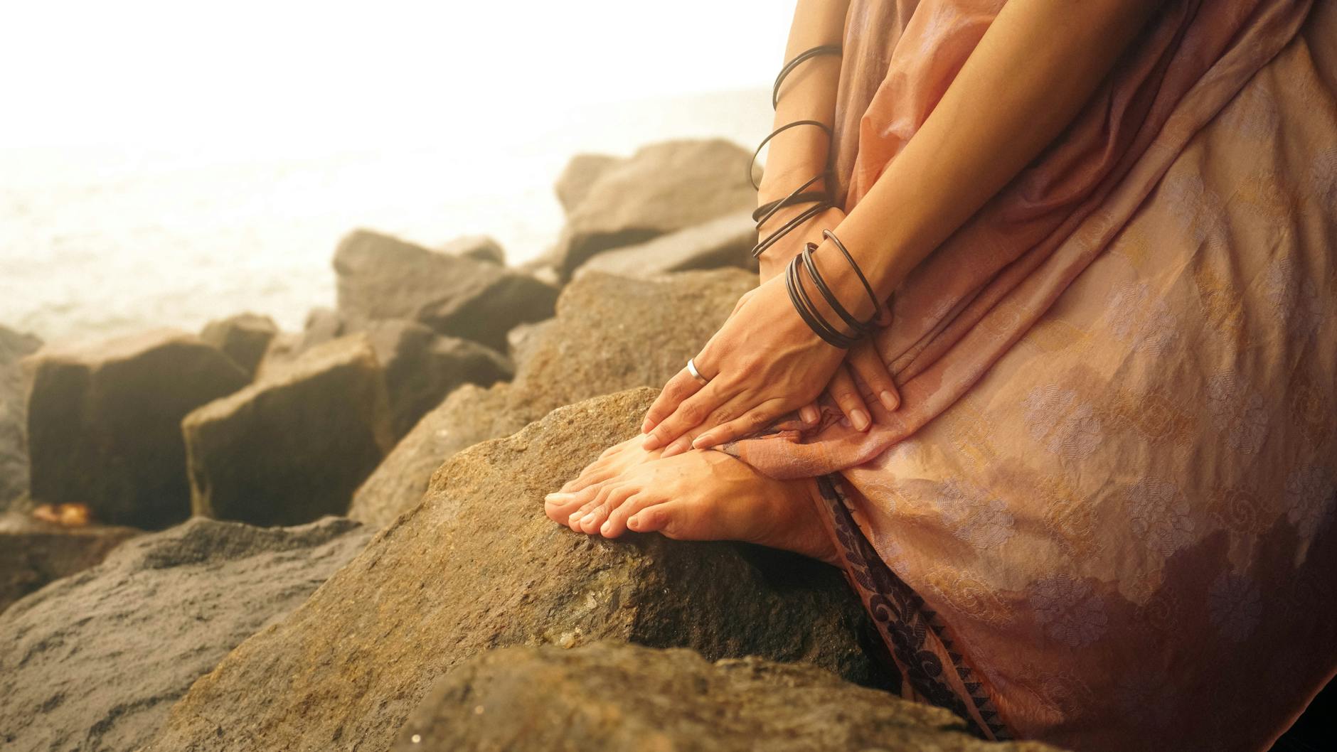 Woman with hands on heart looking upward in a gesture of open trust representing the trust-multiplied new beginning energy of the 2112 angel number