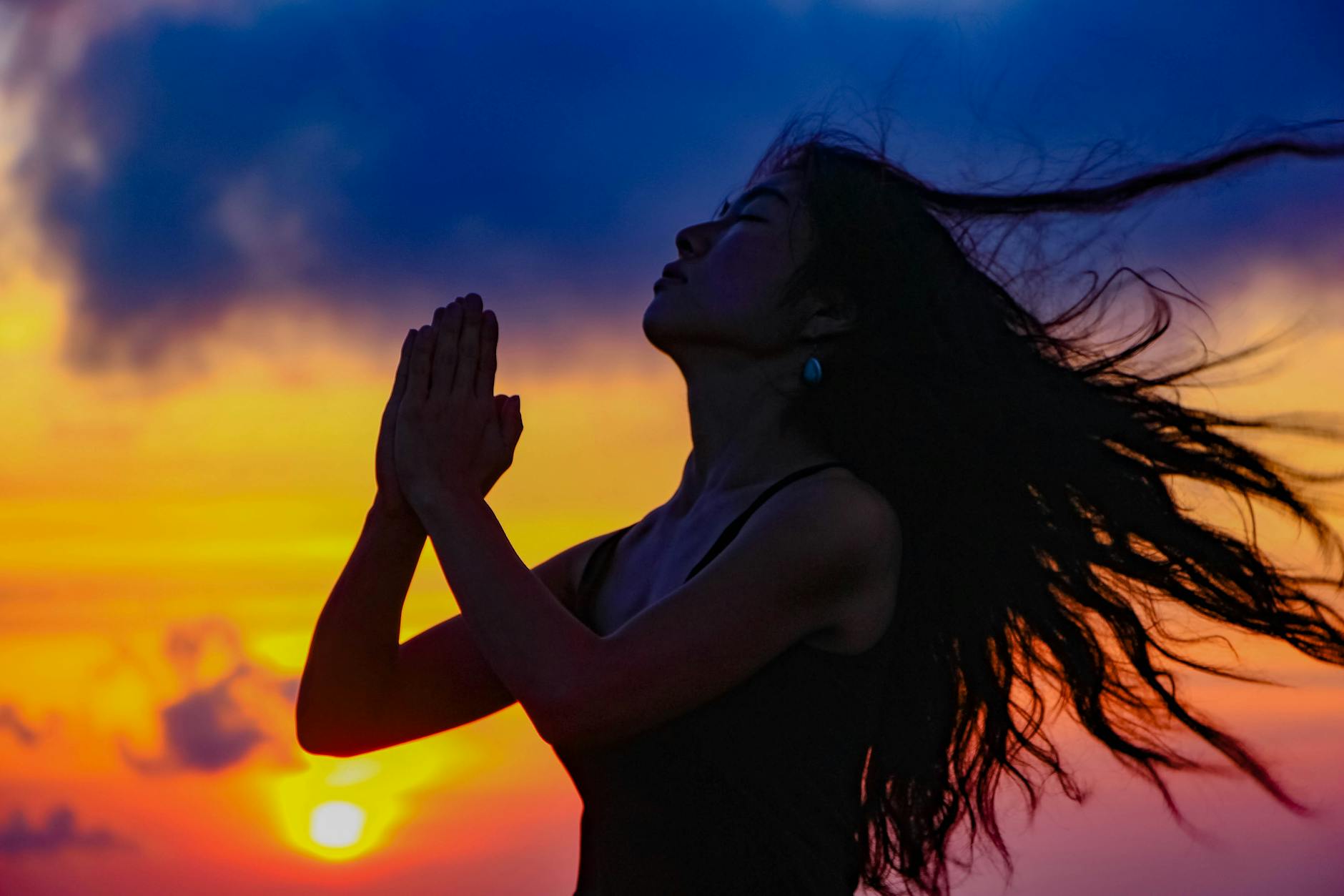 Woman with hands clasped in trust and patience representing the divine timing message of the 2222 angel number