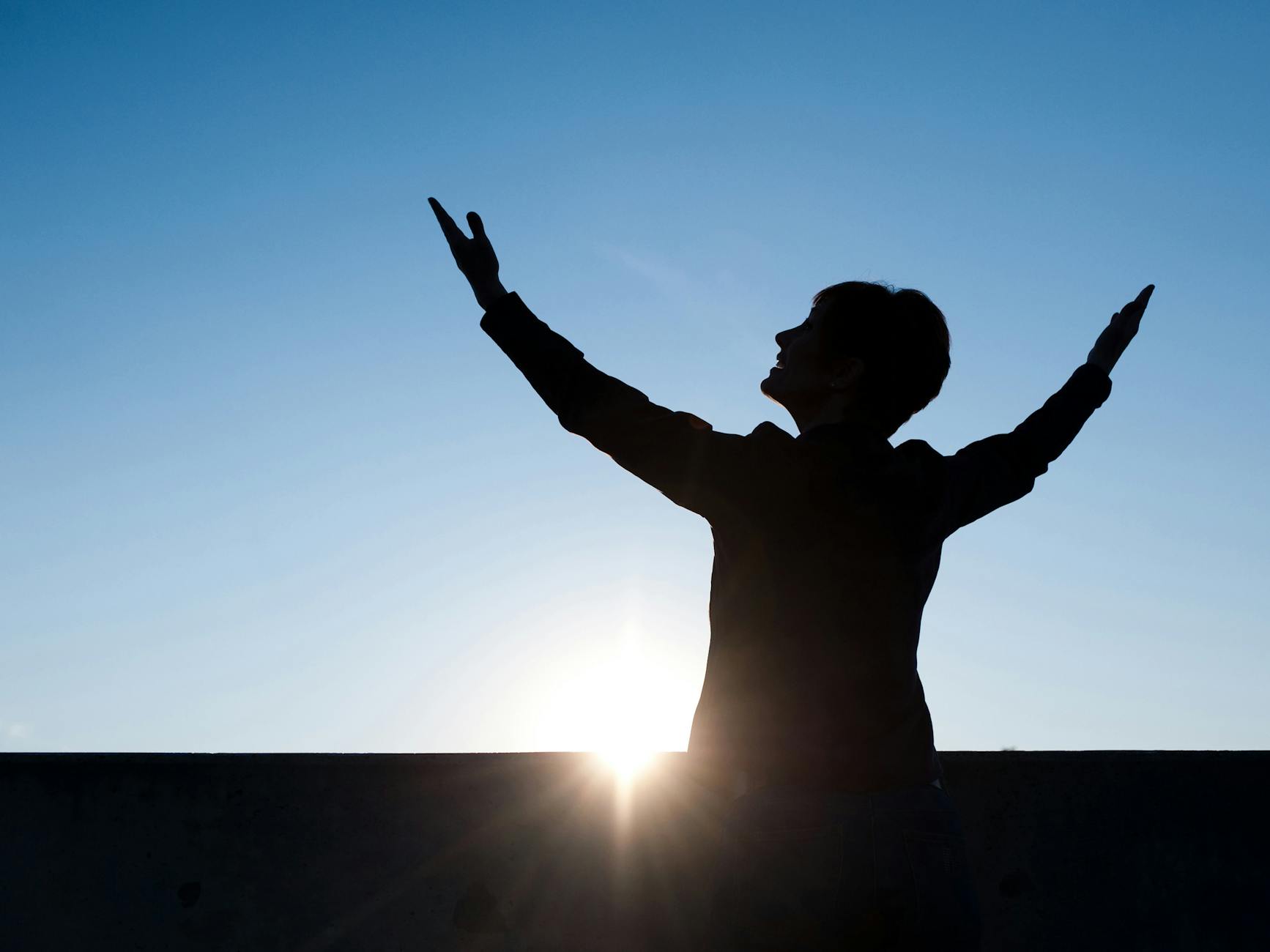 Woman standing at a crossroads at sunrise receiving angelic guidance from the number 225