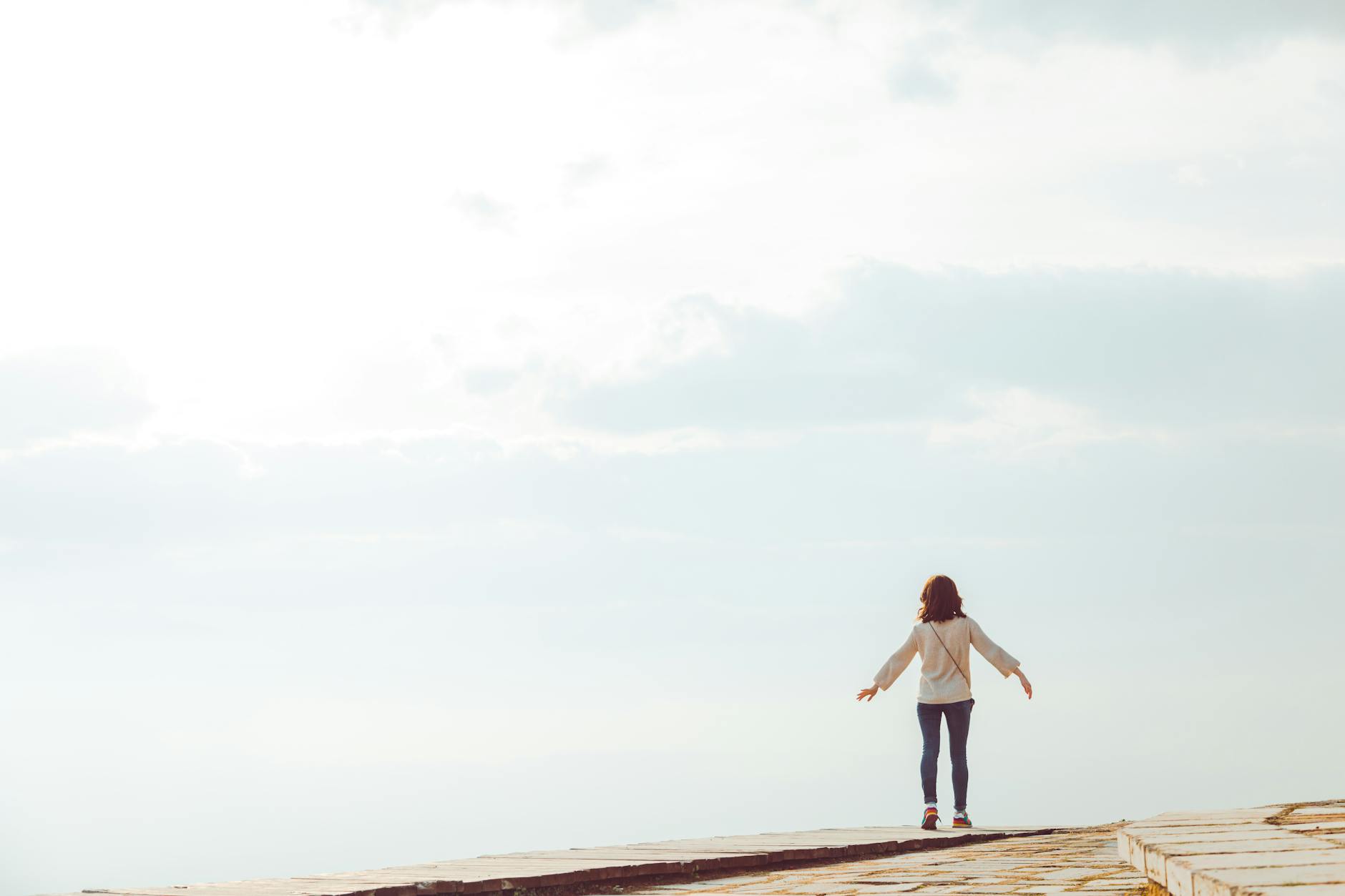 Woman with arms open in a vast landscape representing the freedom and balance energy of the 2525 angel number
