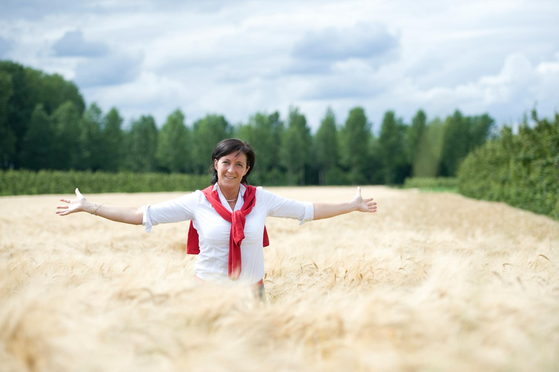 Joyful woman with arms open wide under a glowing celestial sky representing angel number 300