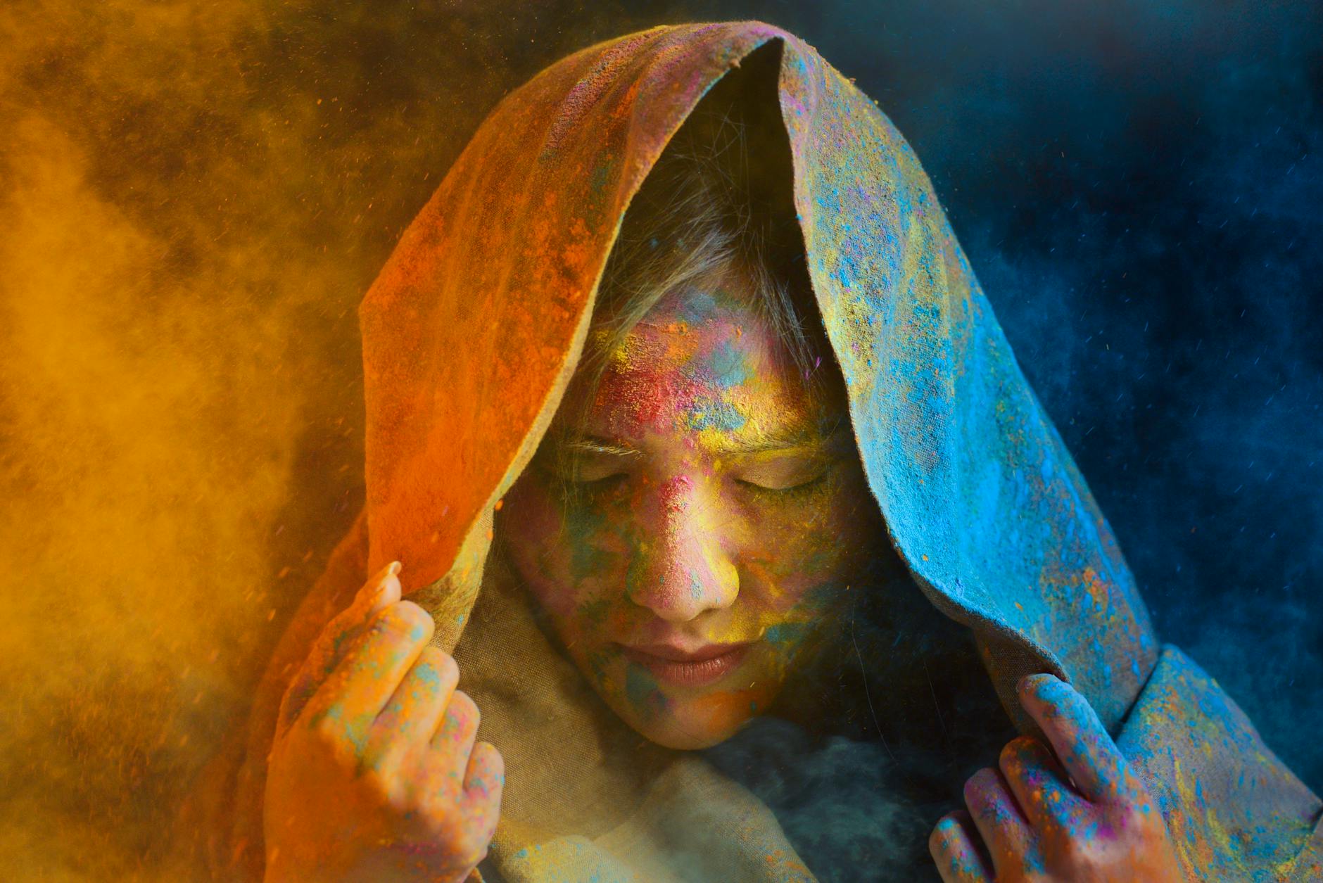 Woman painting with vibrant colors in a studio bathed in light representing the infinitely resourced creative expression energy of the 3003 angel number