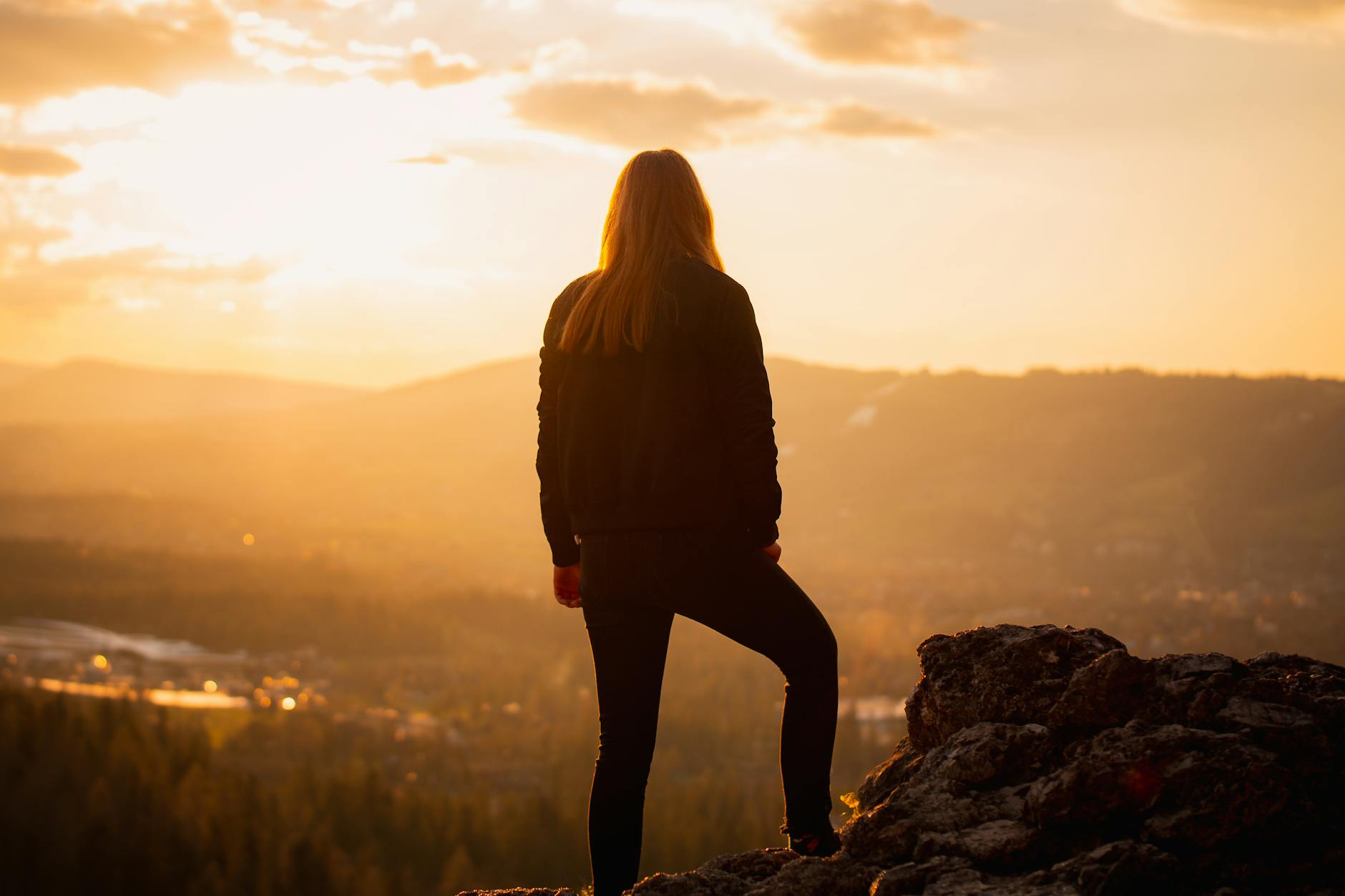 Woman standing powerfully at the edge of a wide landscape representing the grounded freedom and readiness of the 4455 angel number