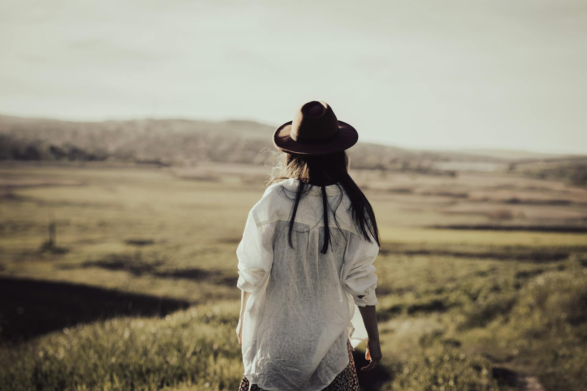 Woman standing confidently at the edge of a wide open landscape representing the grounded freedom energy of the 4545 angel number