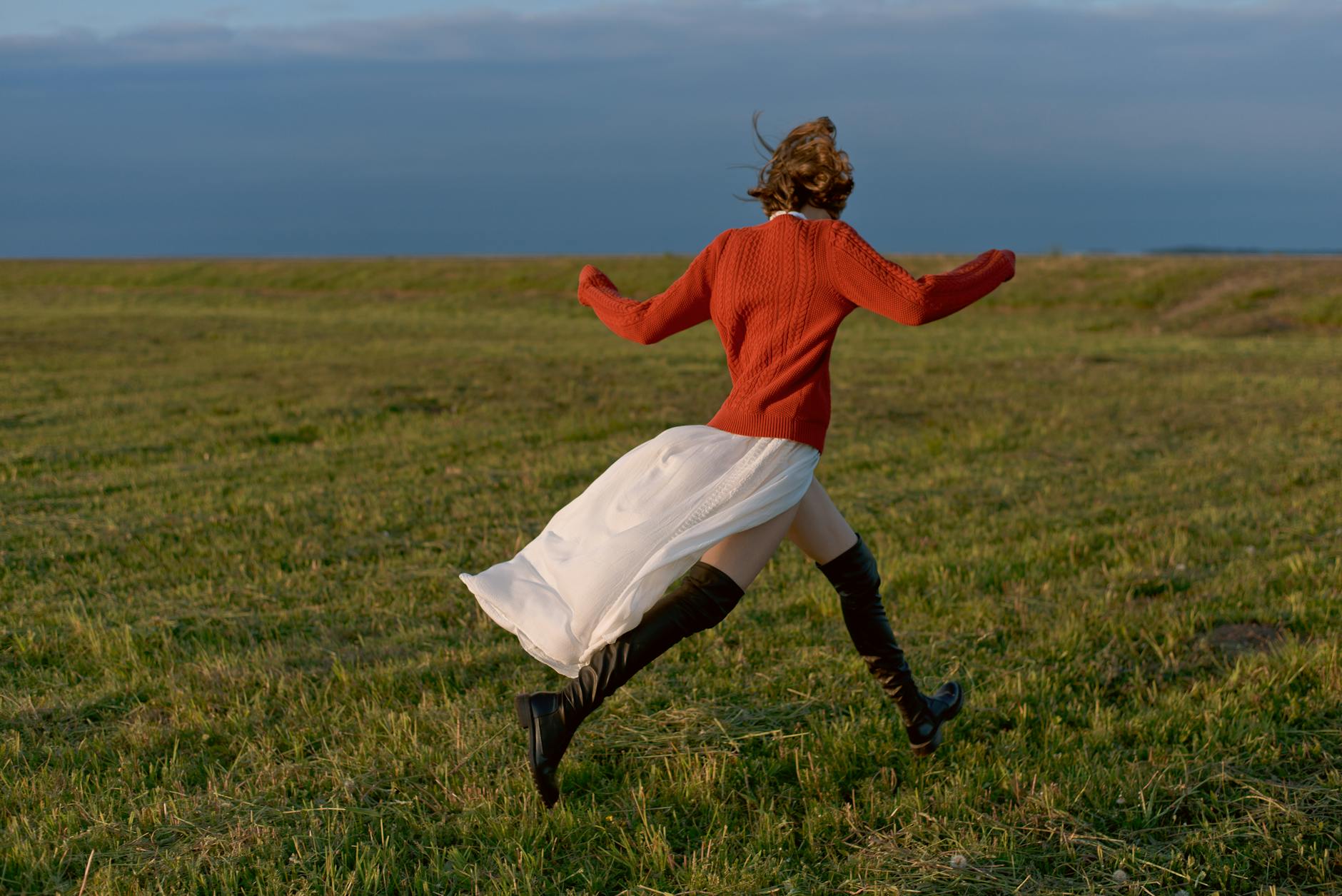 Woman running forward confidently through a sunlit field representing the change-powered new beginning energy of the 5115 angel number