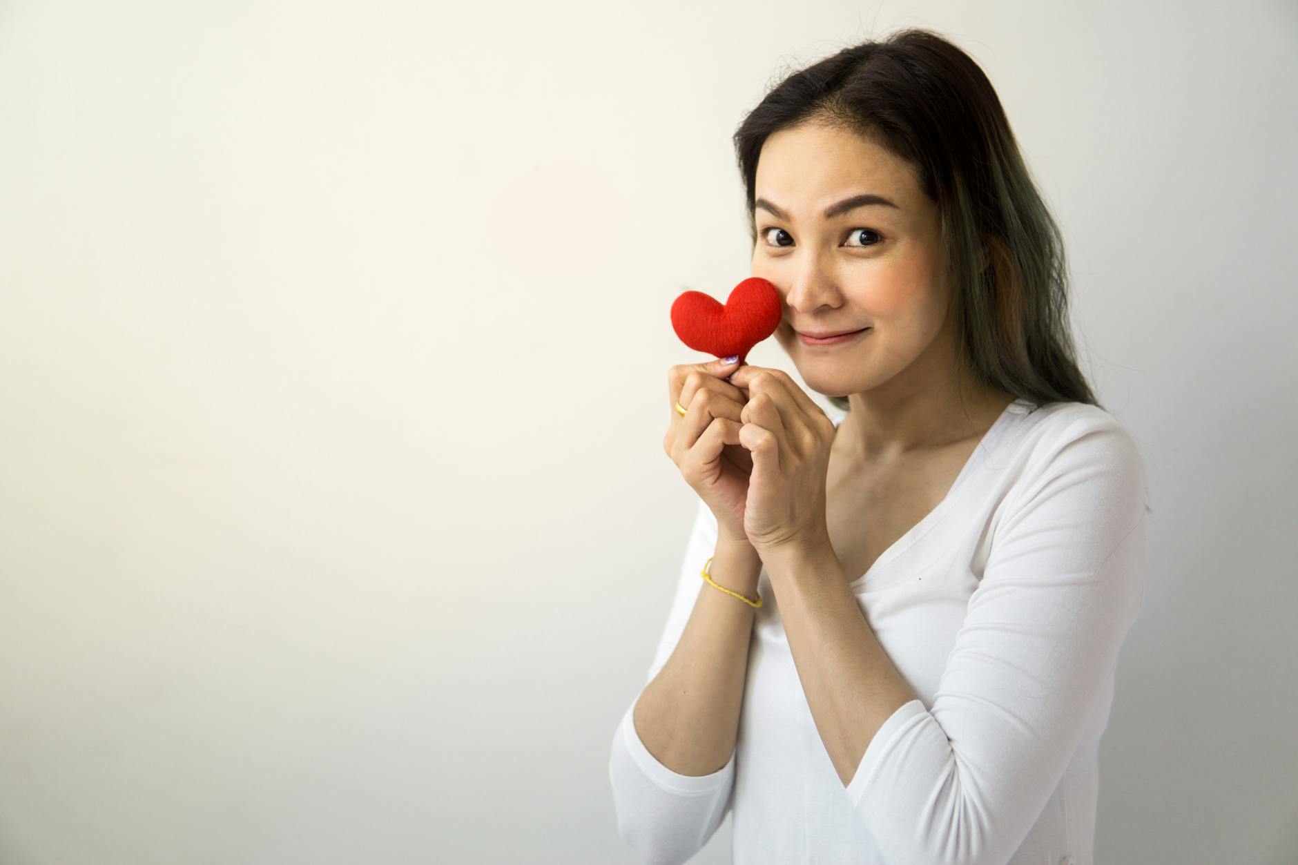 Woman with a radiant open expression in soft light representing the heart opening and love energy of the 6161 angel number