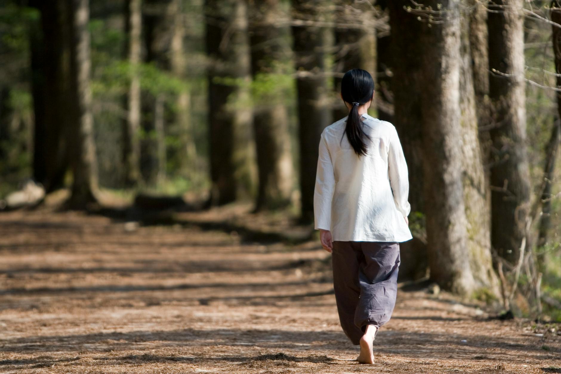 Woman walking confidently on a sunlit path representing the spiritual alignment and confirmed direction of the 747 angel number