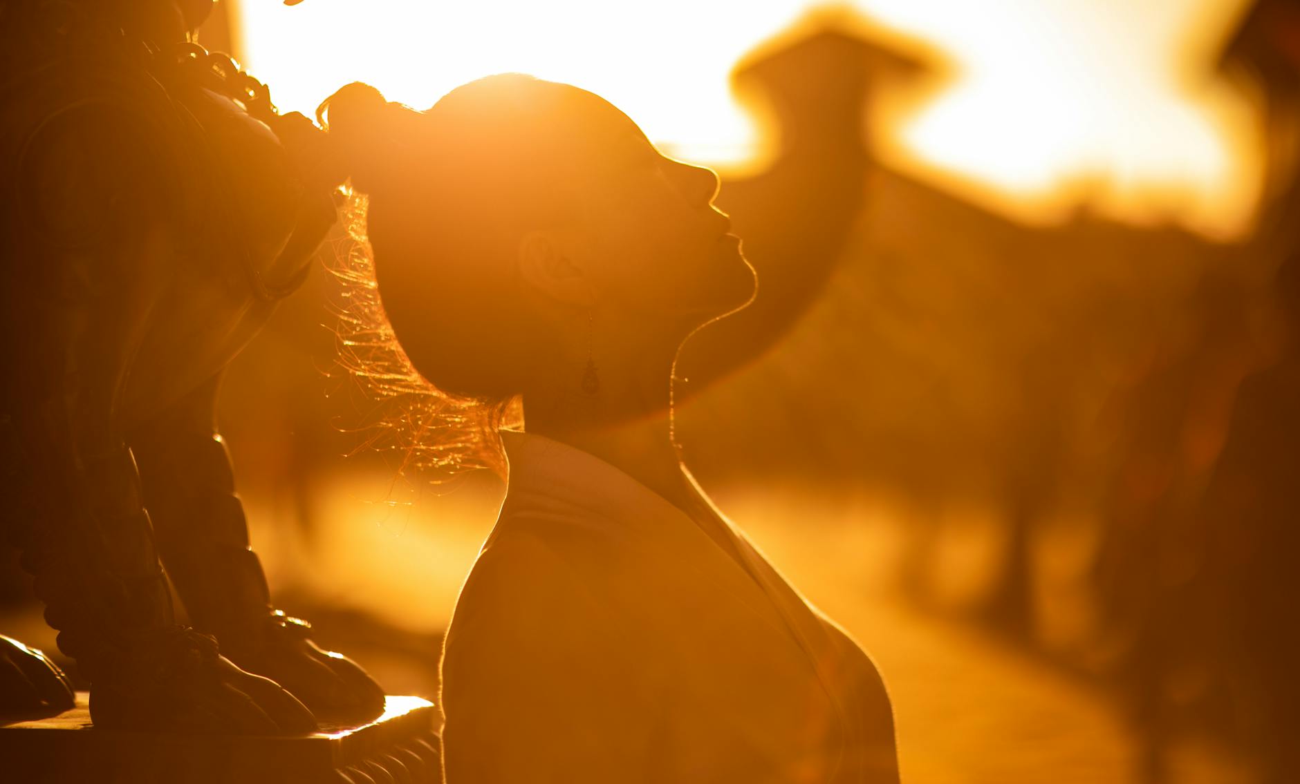 Woman with arms open in golden light representing the infinite abundance and receiving energy of the 8888 angel number