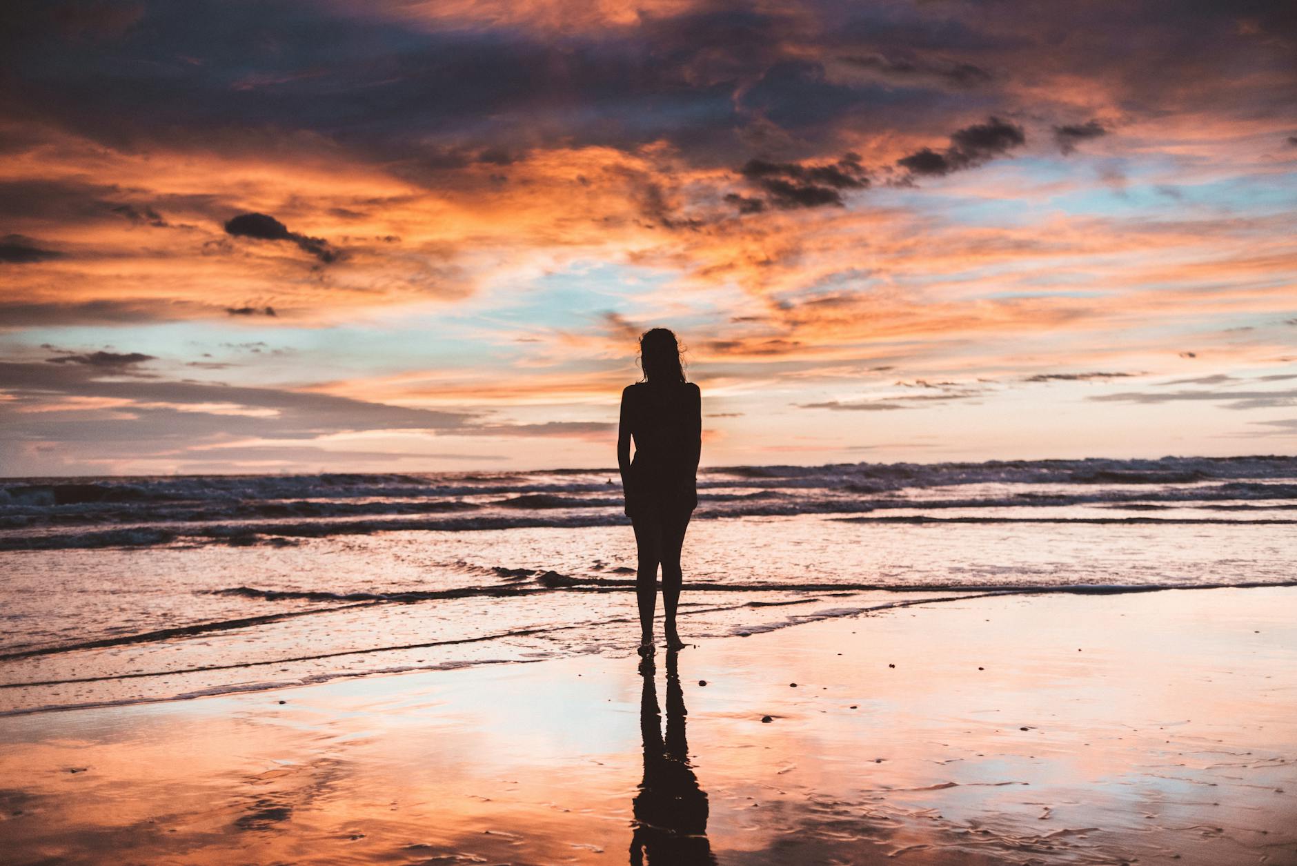 Woman standing at sunset representing the profound completion and release energy of the 9999 angel number